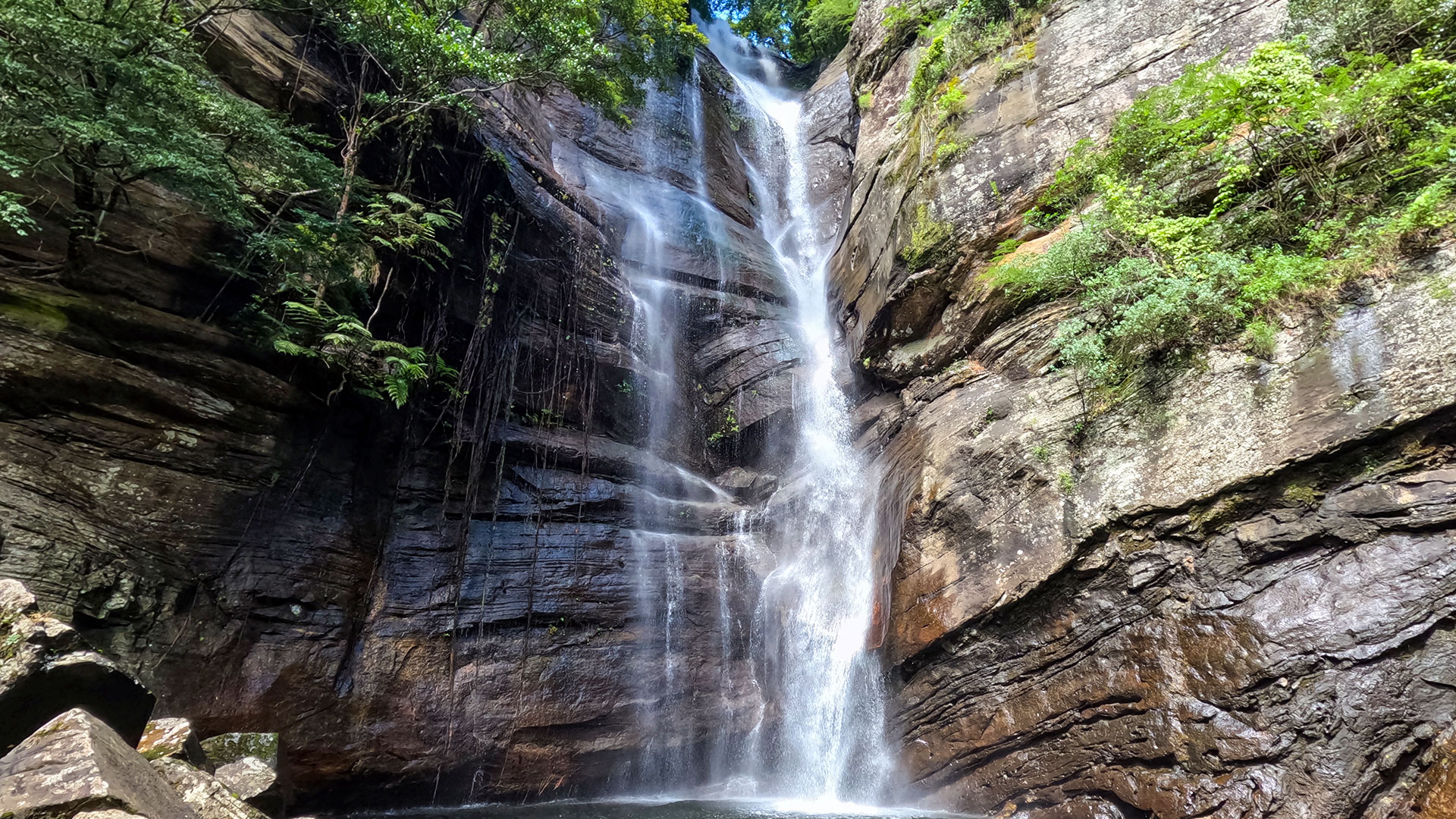 Diyakerella Waterfall cascading through jungle in Meemure with Laggala Mountain backdrop